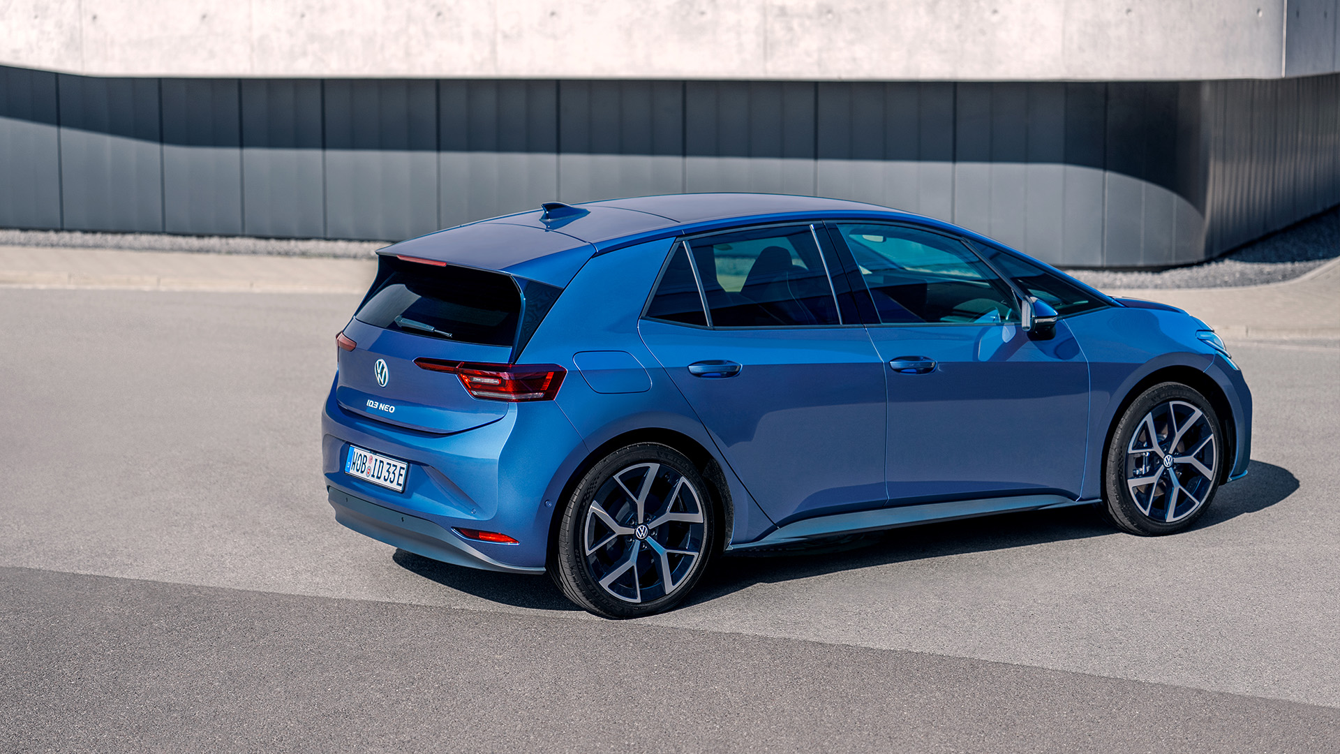 Abstrakt beklebter ID. Cross in gr&uuml;n, im Hintergrund ein Geb&auml;ude aus Glas. Vordere Seitenansicht. 