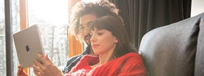 P&auml;rchen sitz auf dem Sofa und schauen auf einem Tablet Stellenangebote an